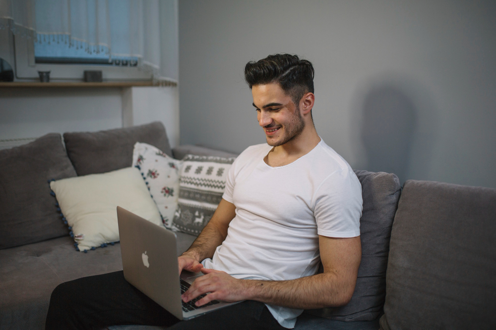 a guy sitting on a couch and using dsl internet