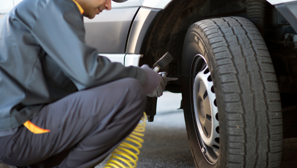 Mechanic,Checking,The,Pressure,Of,A,Van,Tire